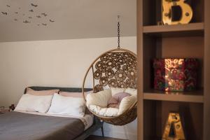 a hanging chair in a room with a bed at VILLA GIULIA 8, Emma Villas in Nemi
