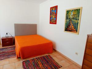 a room with a bed with an orange blanket at Casa da Nelita in São Martinho do Porto +65 photos