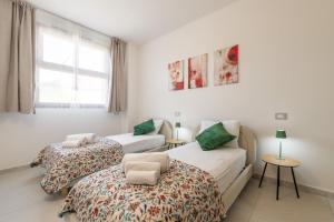 a bedroom with two beds and a chair in it at Domus Luna in Teulada