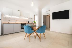 a kitchen with a table and two blue chairs at Domus Luna in Teulada +19 photos
