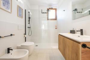 a bathroom with a toilet and a sink and a shower at Domus Luna in Teulada