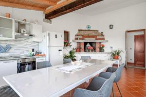 a kitchen with a table and chairs and a fireplace at Villa Montalmutu con vista mare in Nuragheddu