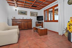 a living room with a couch and a tv at Villa Montalmutu con vista mare in Nuragheddu