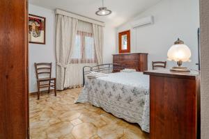 a bedroom with a bed and a table and chairs at Villa Montalmutu con vista mare in Nuragheddu