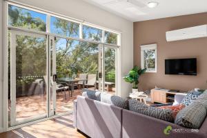 a living room with a couch and a sliding glass door at Phillip Island Resort Villa 148 Amazing Views in Cowes