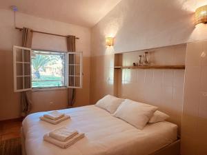 a bedroom with a white bed with two towels on it at Quinta da Vala - Veranda Suite 1 in Porches