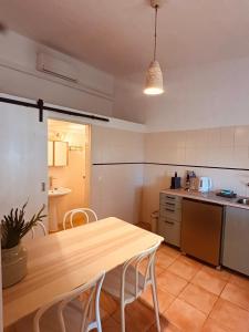 a kitchen with a wooden table in the middle of it at Quinta da Vala - Veranda Suite 1 in Porches