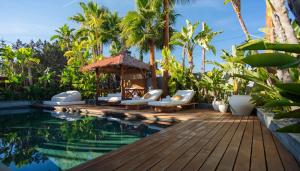 a resort pool with chairs and a gazebo at Villa Ha Taew in Sant Josep de sa Talaia