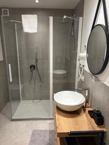 a bathroom with a shower and a white sink at Suite Prestige Apartment in Torri del Benaco