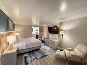 a bedroom with a bed and a desk and a tv at The Aventis Inn in Somers Point