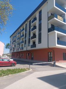 a red car parked in front of a building at Apartman Dzo in Modriča