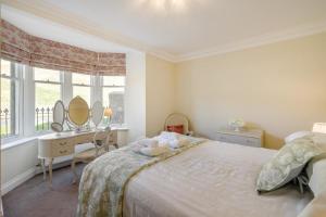 a bedroom with a bed and a desk and a mirror at 3 Bed in Langholm oc-c41365 in Langholm