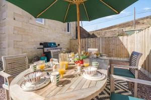 a wooden table with an umbrella on a patio at 3 Bed in Langholm oc-c41365 in Langholm