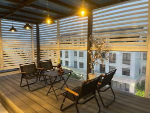 a balcony with a table and chairs and windows at Sunrise Apartments in Xóm Niêm