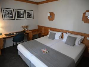 a hotel room with a bed and a desk at Hotel Les Terrasses in Annecy