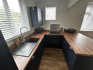 a kitchen with a sink and wooden counter top at Bungalow in Mumbles in The Mumbles +4 photos