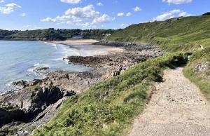 a beach with rocks and the ocean on a hill at Bungalow in Mumbles in The Mumbles