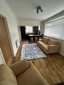 a living room with two couches and a table at Bungalow in Mumbles in The Mumbles