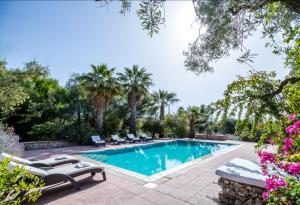 a swimming pool in a yard with chairs and trees at Villa Aeolus Stylish Villa with Pool Masterbedroom with seperate Mezzanine in Koríthion