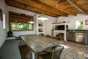 a kitchen with a large wooden table and chairs at Villa Aeolus Stylish Villa with Pool Masterbedroom with seperate Mezzanine in Koríthion