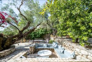 a garden with a bench and trees in the background at Villa Aeolus Stylish Villa with Pool Masterbedroom with seperate Mezzanine in Koríthion