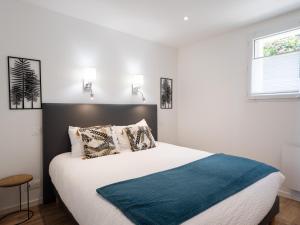 a bedroom with a large bed with a blue blanket at Gites Au Point De Vue in Perros-Guirec