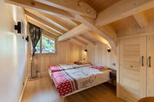a bedroom in a log cabin with a bed at Chalet Individuel - Saflalou in Combloux