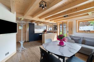 a kitchen and a living room with a table and chairs at Chalet Individuel - Saflalou in Combloux