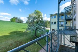 a balcony of a house with a tree in the yard at Apartment mit Gartenblick K1 106 in Spalt