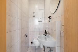 a white bathroom with a sink and a toilet at Apartment mit Gartenblick K1 106 in Spalt +17 photos