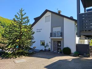 a christmas tree in front of a white building at Pension Mosella , Appartement-Wohnung mit Balkon und Moselblick in Sankt Aldegund +2 photos