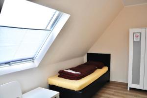 a room with a bed sitting under a skylight at Pension Highway - Bünde Borriesstraße 39 in Bünde