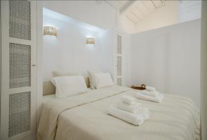 a white bedroom with white towels on a bed at Stavlo Open Plan Cottage Zakynthos in Koríthion