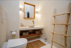 a bathroom with a sink and a toilet and a mirror at Stavlo Open Plan Cottage Zakynthos in Koríthion