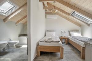 a bedroom with two beds and a sink in a attic at Villa Pilali in Kefallonia