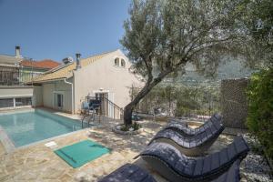 a villa with a swimming pool and a tree at Villa Pilali in Kefallonia