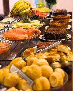 a buffet with many plates of food on a table at Canas Gold Praia Hotel in Florianópolis