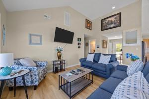 a living room with blue couches and a tv at 7659 - Sound Garden in Avon