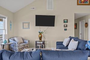 a living room with a blue couch and a tv at 7659 - Sound Garden in Avon