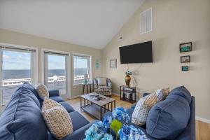a living room with a blue couch and a flat screen tv at 7659 - Sound Garden in Avon +44 photos