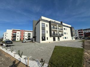 a large white building with a parking lot at VISAJ Jacuzzi Romantic in Timişoara