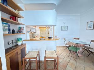 a kitchen with a table and some chairs and a table at Domus Floris in Positano