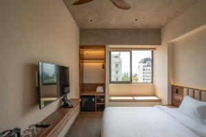 a hotel room with a bed and a flat screen tv at The Charm Hotel Phan Thiet in Ấp Bình Hưng +15 photos