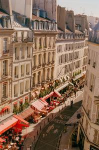 a street with cafes and restaurants in a city at Hôtel De Buci in Paris