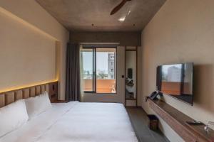 a bedroom with a large bed and a large window at The Charm Hotel Phan Thiet in Ấp Bình Hưng