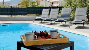 a tray of fruit on a table next to a swimming pool at Moonlight Luxury Apartment with Private Pool and Parking in Kaštela +33 photos