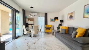 a living room with a couch and a table at Moonlight Luxury Apartment with Private Pool and Parking in Kaštela