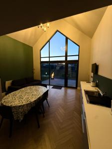 a living room with a table and a large window at Wild Atlantic Camp in Creeslough