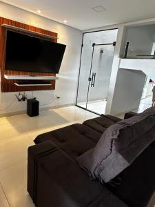 a living room with a couch and a flat screen tv at Sobrado amplo com churrasqueira in Rio Verde