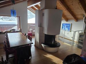 a living room with a fireplace and a dining room table at la casa del marmottaio in Crépin